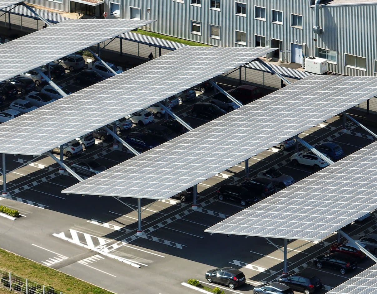 Solar carport canopy shading a row of parked cars at a commercial property