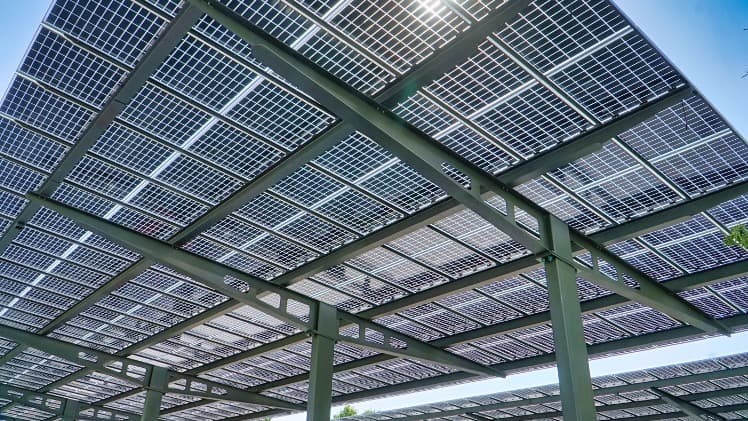 Galvanized structural steel solar carport frame over a commercial parking lot